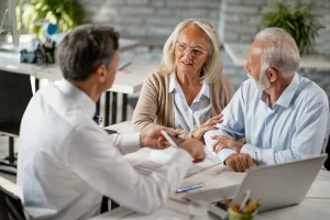business owners sitting at table discussing group insurance options with advisor in office