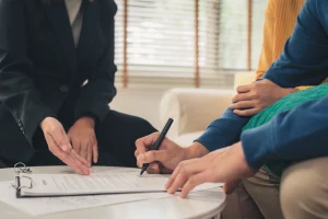 close up of clients signing insurance paperwork for self employment insurance
