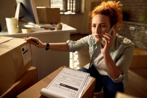 Woman handling paperwork and phone calls after a recent move