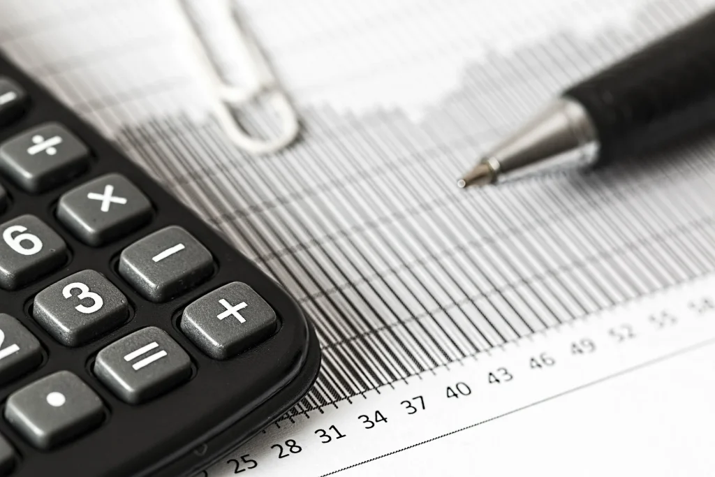 close up of calculator and pen on printed financial chart