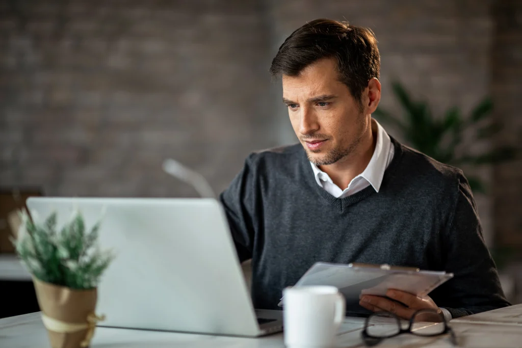 man researching short term health insurance options on laptop