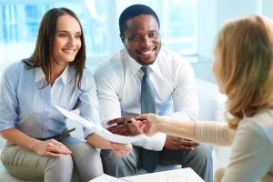 smiling couple reviewing health insurance for married couples_ in bright office