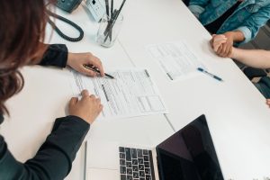 Insurance representative reviewing employee vision insurance forms and coverage options with a client